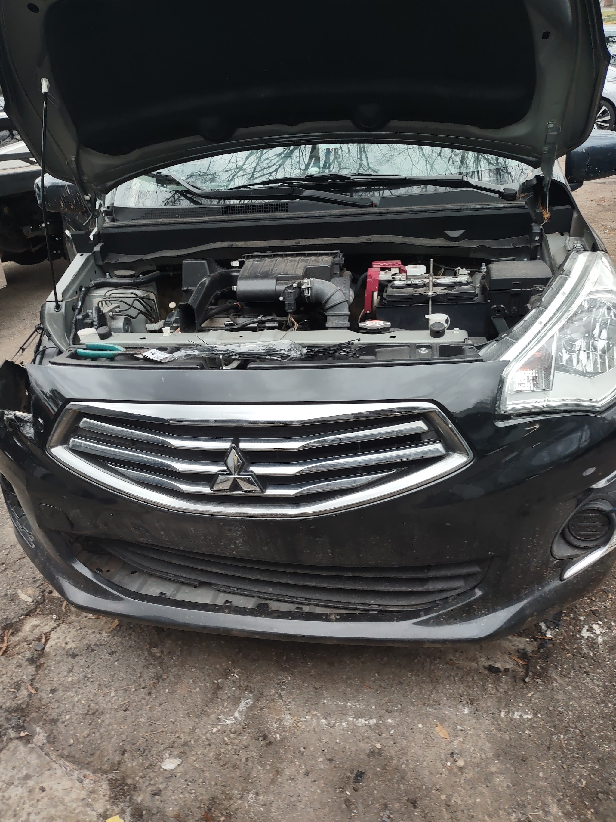 Black Mitsubishi front end with the hood raised