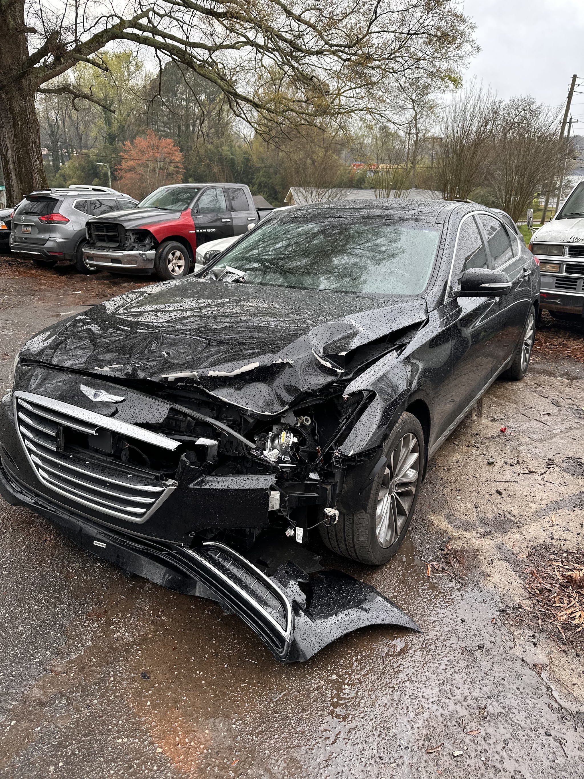 Black sedan with front end collision damage waiting in our yard