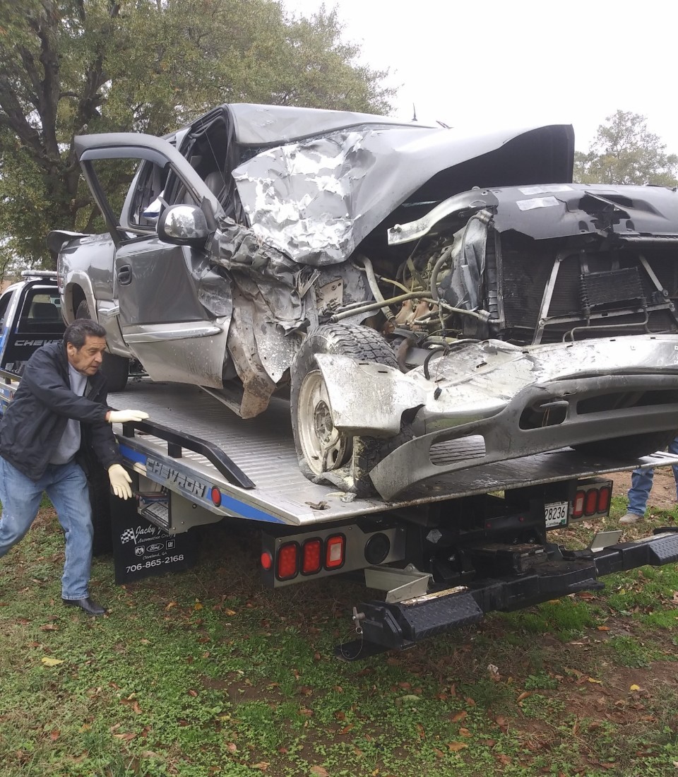 A wrecked pickup being winched onto our flatbed